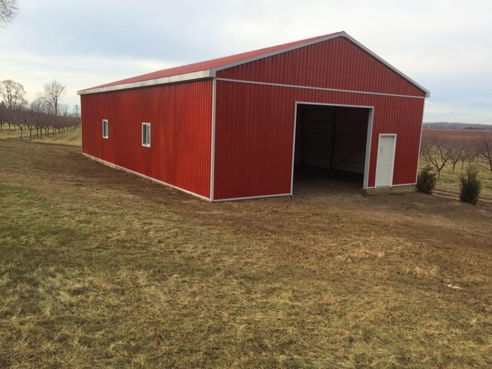 A red barn with a door open and no windows.