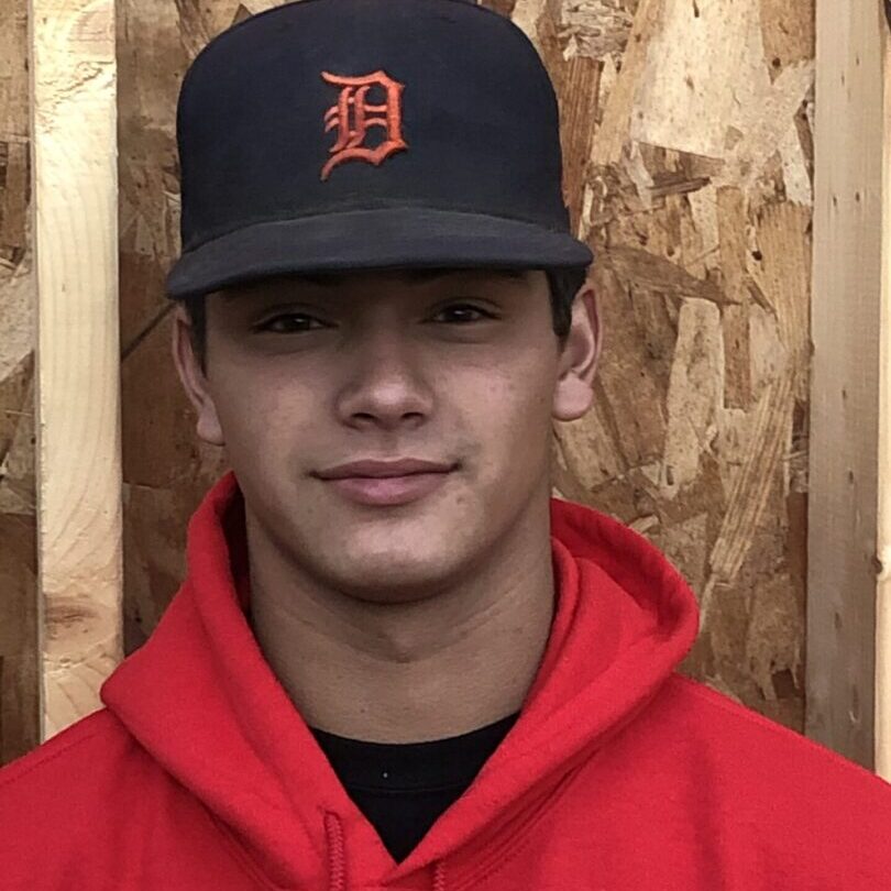 A man in red jacket wearing a baseball cap.